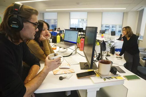 John D'Amico, deputy executive editor for The News Movement (TNM), a social media news operation re-imagined for Gen-Z consumers, left, reviews video with reporter Kimberly Avalos, Wednesday, March 1, 2023, in New York. TNM uses a staff of reporters with an average age of 25 to make tailored news content for sites like TikTok, Instagram, YouTube and Twitter. (AP Photo/Bebeto Matthews)