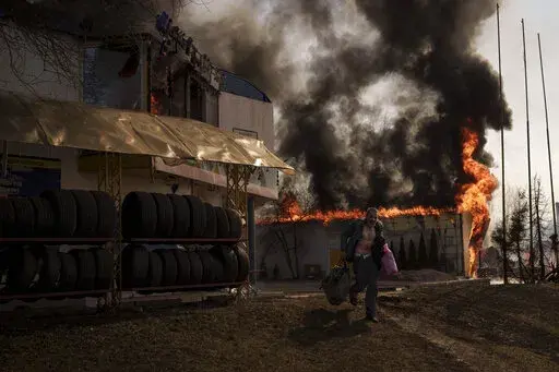 A man recovers items from a shop that caught fire from a Russian attack in Kharkiv, Ukraine, Friday, March 25, 2022. (AP Photo/Felipe Dana)