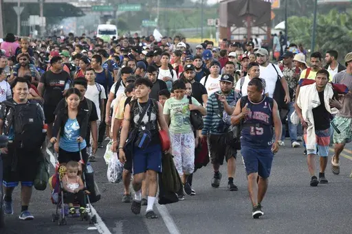 Migrants walk along the highway through Suchiate, Chiapas state in southern Mexico, Sunday, July 21, 2024, during their journey north toward the U.S. border. (AP Photo/Edgar H. Clemente)