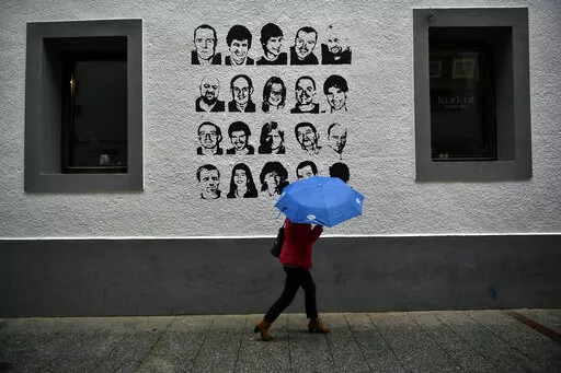 A woman shelters from the rain under an umbrella, while walking past a wall painted with portraits of prisoners of the Basque separatist armed group ETA, in the small village of Hernani, northern Spain, May 2, 2018. The United States is poised to remove five extremist groups, all believed to be defunct, from its list of foreign terrorist organizations. Several of these groups once posed significant threats, killing hundreds if not thousands of people across Asia, Europe and the Middle East. The 