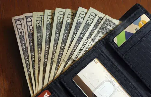 In this June 15, 2018, file photo, cash is fanned out from a wallet in North Andover, Mass. (AP Photo/Elise Amendola, File)