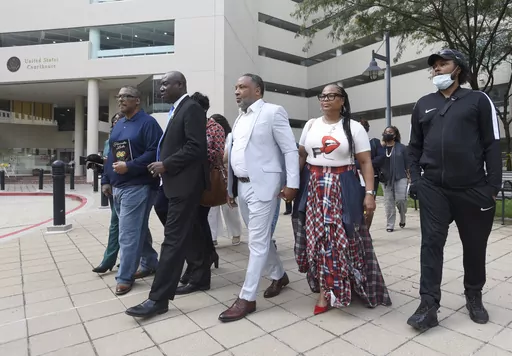 Attorney Ben Crump, second from left, walks with Ron Lacks, left, Alfred Lacks Carter, third from left, both grandsons of Henrietta Lacks, and other descendants of Lacks, outside the federal courthouse in Baltimore, Oct. 4, 2021. The family of Henrietta Lacks is settling a lawsuit against a biotechnology company it accuses of improperly profiting from her cells. Their federal lawsuit in Baltimore claimed Thermo Fisher Scientific has made billions from tissue taken without the Black woman’s con