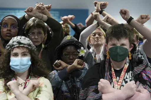 Activists demonstrate in silence protesting a draft of a proposed deal for curbing climate change at the COP29 U.N. Climate Summit, Friday, Nov. 22, 2024, in Baku, Azerbaijan. (AP Photo/Joshua A. Bickel)