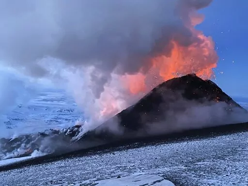 Flames and smoke billowing during the Klyuchevskaya volcano's eruption on the Kamchatka Peninsula in Russia, on March 8, 2021. Towering clouds of ash and glowing lava are spewing from two volcanoes on the Kamchatka Peninsula and scientists say major eruptions could be on the way. The sudden new activity followed a strong earthquake on Saturday Nov. 19, 2022, news reports said.  (AP Photo/Boris Smirnov, File)