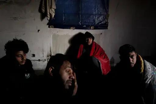 Migrants gather near the Hungarian border, outside of the village of Martonosh, Serbia, Thursday, Jan. 13, 2022. Hungary's nationalist prime minister, Viktor Orban, is keen to use the threat of migrants at his country's southern border to give him an advantage in upcoming elections. But the scale of migration pressure claimed by Orban is drawn into question by statistics from neighboring Serbia and the European Union's border agency.  (AP Photo/Bela Szandelszky)