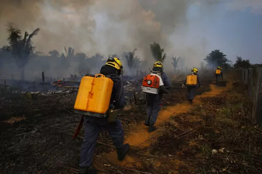 Fire brigade members walk in to a burnt area in Apui, Amazonas state, Brazil, Sept. 21, 2022. Despite the smoke clogging the air of entire Amazon cities, state elections have largely ignored environmental issues. Far-right President Jair Bolsonaro is seeking a second four-year term against leftist Luiz Inácio Lula da Silva, who ruled Brazil between 2003 and 2010. (AP Photo/Edmar Barros, File)