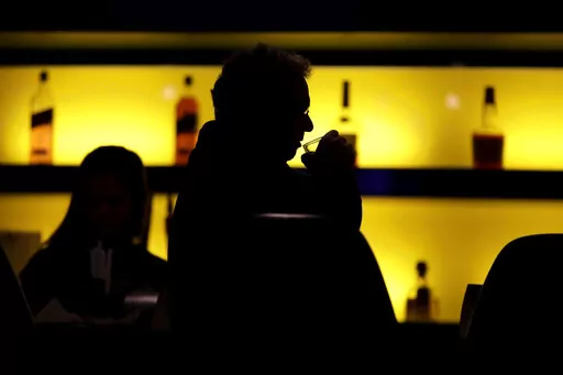 In this Nov. 30, 2017 photo, a patron sips his drink while having a meal at a bar in New Jersey. More government data points to alcohol's increasing role in U.S deaths, including a new report that found that the alcohol-induced death rate rose nearly 30% during the first year of the COVID-19 pandemic. (AP Photo/Julio Cortez, File)