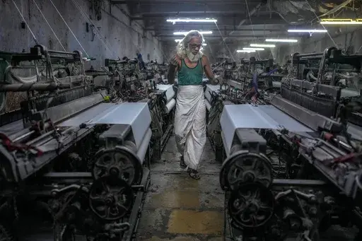 Abdul Sattar, 70, operates a power loom at a workshop in Bhiwandi, India, Feb. 25, 2025. (AP Photo/Rafiq Maqbool)