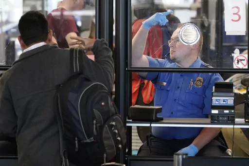 A Transportation Security Administration agent signals for the next airline passenger in line at a security checkpoint in Chicago's O'Hare International Airport Friday, May 26, 2023. On Aug. 25, The Associated Press reported on stories circulating online incorrectly claiming TSA managers were told on Aug. 15 that by mid-September they, along with airport employees, will again be required to wear face masks and by mid-October the policy will apply to travelers as well. (AP Photo/Charles Rex Arbog