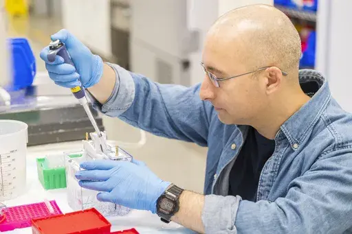 A lab technician prepares DNA samples for analysis at Complete Genomics in San Jose, Calif., Monday, July 22, 2024. (AP Photo/Nic Coury)