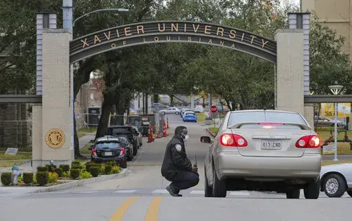A Xavier University police officer redirects a motorist around campus after a bomb threat put the campus on lockdown in New Orleans, La., Feb. 1, 2022. As the nation’s historically Black colleges remain on edge after receiving dozens of bomb threats in recent weeks, federal law enforcement officials said they have identified six suspects who they believe are responsible for most of the racially motivated crimes. (David Grunfeld/The Advocate via AP, File)