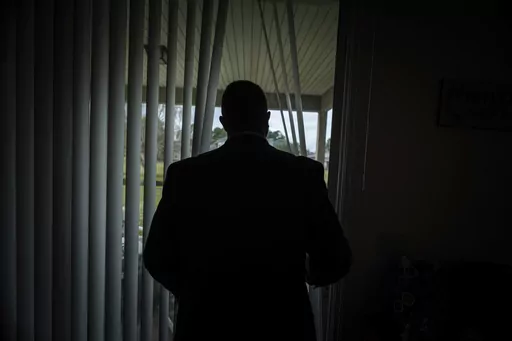 Joseph Moore looks out of a window at his home in Jacksonville, Fla., on Tuesday, Dec. 7, 2021. Moore worked for nearly 10 years as an undercover informant for the FBI, infiltrating the Ku Klux Klan in Florida, foiling at least two murder plots, according to investigators, and investigating ties between law enforcement and the white supremacist organization. "From where I sat, with the intelligence laid out, I can tell you that none of these agencies have any control over any of it. It is more p