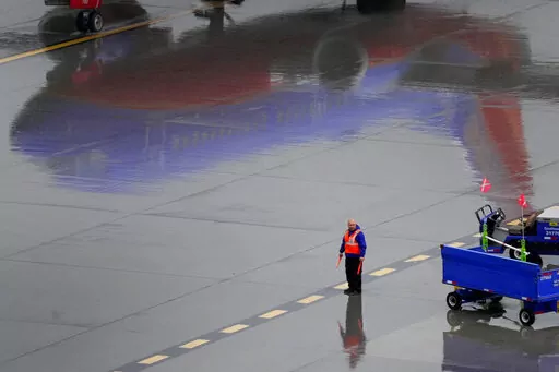 A Southwest Airlines ground operations crew member waits to guide an arriving jet into a gate, Wednesday, Dec. 28, 2022, at Sky Harbor International Airport in Phoenix. Travelers who counted on Southwest Airlines to get them home suffered another wave of canceled flights Wednesday, and pressure grew on the federal government to help customers get reimbursed for unexpected expenses they incurred because of the airline’s meltdown. (AP Photo/Matt York)