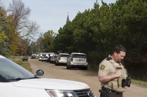 A Benton County sheriff establishes a security perimeter at the intersection of 186th Avenue NE and Glendorado Road NE near Princeton, Minn., following a "critical incident," Thursday, Oct. 10, 2023. Authorities say a suspect has been arrested after five drug task force officers were shot and wounded while serving a search warrant near the Minnesota city of Princeton. (Tim Evans/Minnesota Public Radio via AP)