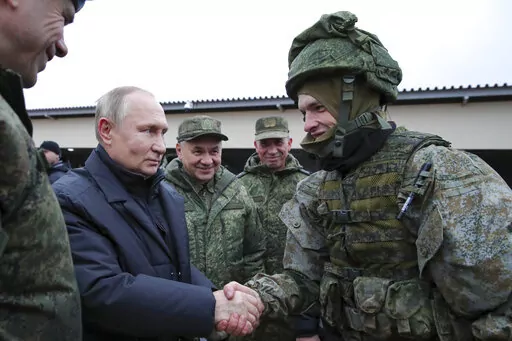 Russian President Vladimir Putin shakes hands with a soldier as he visits a military training centre of the Western Military District for mobilised reservists as Russian Defense Minister Sergei Shoigu, center, smiles in Ryazan Region, Russia, Thursday, Oct. 20, 2022. The mobilized reservists that Russian President Vladimir Putin visited last week at a firing range southeast of Moscow looked picture-perfect. (Mikhail Klimentyev, Sputnik, Kremlin Pool Photo via AP, File)
