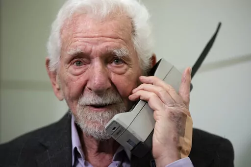 Marty Cooper, the inventor of first commercial mobile phone, poses for the press with a Motorola DynaTAC 8000x, during an interview with The Associated Press at the Mobile World Congress 2023 in Barcelona, Spain, Monday, Feb. 27, 2023. The four-day show kicks off Monday in a vast Barcelona conference center. It's the world's biggest and most influential meeting for the mobile tech industry. (AP Photo/Joan Mateu Parra)