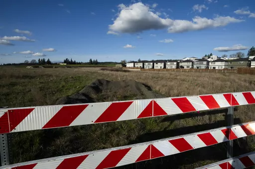 Homes are seen on Thursday, Feb. 22, 2024, in the southwest Portland, Ore., suburb of Beaverton. The so-called urban growth boundary, established by a 1973 law that placed boundaries around cities to prevent urban sprawl and preserve nature and farmland, is seen in the background along SW Tile Flat Road. (AP Photo/Jenny Kane)