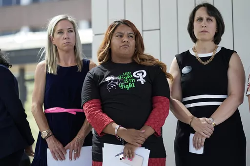 Amanda Zurawski, who developed sepsis and nearly died after being refused an abortion when her water broke at 18 weeks, left, and Samantha Casiano, who was forced to carry a nonviable pregnancy to term and give birth to a baby who died four hours after birth, center, stand with their attorney Molly Duane outside the Travis County Courthouse, Wednesday, July 19, 2023, in Austin, Texas. A Texas judge ruled Friday, Aug. 4, 2023, the state’s abortion ban has proven too restrictive for women with s