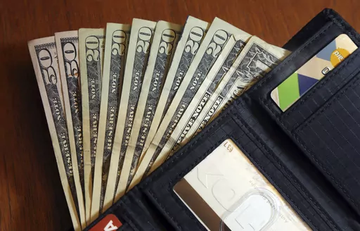 Cash is fanned out from a wallet in North Andover, Mass., June 15, 2018. Some people may want to fast-track their savings because they have early retirement goals or want to catch up after a period of not saving as much as desired. No matter what your motivation is, it’s possible to increase your retirement savings by getting a side hustle. However, it’s important to have a plan in place for that side hustle income so the money goes toward your retirement goals and not other expenses. (AP Ph