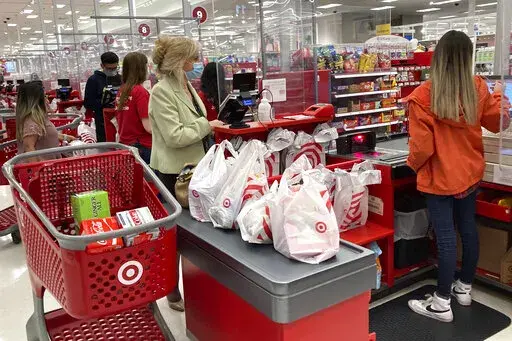 A customer wears a mask as she waits to get a receipt at a register in Target store in Vernon Hills, Ill., Sunday, May 23, 2021.  Retail sales rose modestly in March 2022, but higher prices for food, gasoline and other basics took a big share of their wallet. Retail sales increased 0.5% after registering a revised 0.8% jump from January to February.  (AP Photo/Nam Y. Huh, File)