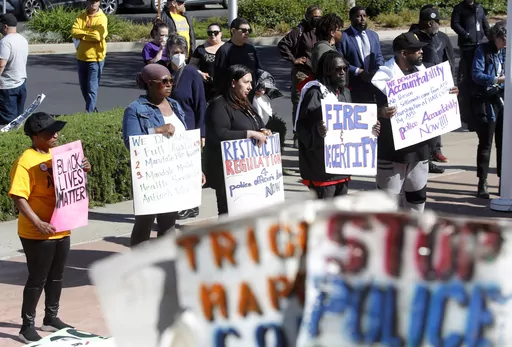 Community members listen to speakers during a rally at Antioch police headquarters in Antioch, Calif., on April 18, 2023. Racist police text messages containing slurs and images of gorillas will take center stage in a San Francisco Bay Area courtroom on Friday, July 21, 2023, as a judge weighs whether the messages violated a state law designed to stamp out racism in the criminal court system. (Jane Tyska/Bay Area News Group via AP)