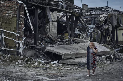 A woman reacts at the scene of a building damaged after recent Russian missile strikes in Pokrovsk, Donetsk region, Ukraine, , Wednesday, Aug. 9, 2023. (AP Photo/Libkos)