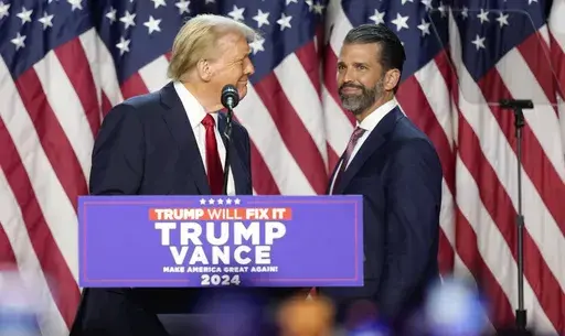 Republican presidential nominee former President Donald Trump, left, looks at his son Donald Trump Jr. at an election night watch party, Nov. 6, 2024, in West Palm Beach, Fla. (AP Photo/Alex Brandon, File)