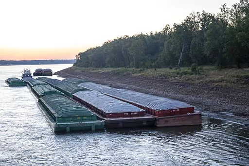 Barges idle while waiting for passage in the Mississippi River near Vicksburg, Miss., on Tuesday, Oct. 4, 2022. The unusually low water level in the lower Mississippi River is causing barges to get stuck in the muddy river bottom, resulting in delays. The U.S. Coast Guard said Tuesday, Oct. 4, 2022, that at least eight “groundings” of barges have been reported in the past week, despite low-water restrictions on the barge loads. (Thomas Berner via AP)