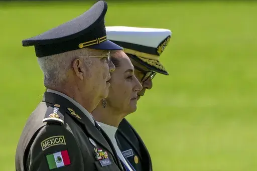 Mexican President Claudia Sheinbaum, center, reviews the troops with Defense Minister Gen. Ricardo Trevilla Trejo, left, and Navy Secretary Alt. Raymundo Pedro Morales, at Campo Marte in Mexico City, Oct. 3, 2024. (AP Photo/Fernando Llano, File)