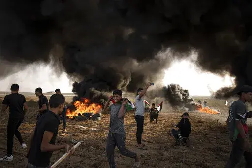 Palestinians burn tires during a protest against Israeli military raid in the West Bank, along the border fence with Israel, in east of Gaza City on Oct. 25, 2022. The U.N. Mideast envoy said 2022 is on course to be the deadliest year for Palestinians in the West Bank since the U.N. started tracking fatalities in 2005, and he called for immediate action to calm "an explosive situation" and move toward renewing Israeli-Palestinian negotiations. (AP Photo/Fatima Shbair, File)