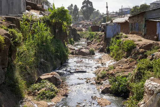 A tributary full of garbage, which feeds into the Nairobi River, flows through the informal settlement of Kibera in Nairobi, Kenya, Wednesday, Jan. 11, 2023. As clean water runs short, one of Africa's fastest growing cities is struggling to balance the needs of creating jobs and protecting the environment, and the population of over 4 million feels the strain. (AP Photo/Khalil Senosi)