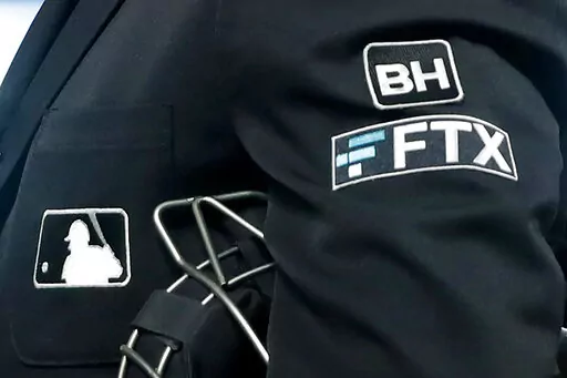 The FTX logo appears on home plate umpire Jansen Visconti's jacket at a baseball game with the Minnesota Twins on Tuesday, Sept. 27, 2022, in Minneapolis. Embattled cryptocurrency exchange FTX, short billions of dollars, is seeking bankruptcy protection, Friday, Nov. 11,  following its collapse this week.  (AP Photo/Bruce Kluckhohn, File)