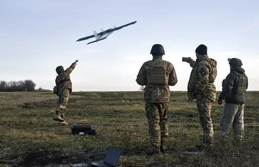 Ukrainian soldiers launch a drone at Russian positions near Bakhmut, Donetsk region, Ukraine, Thursday, Dec. 15, 2022. (AP Photo/LIBKOS)