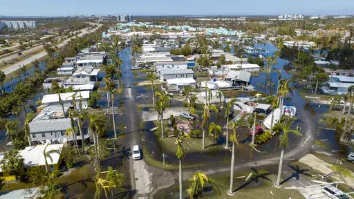 Water floods a damaged trailer park in Fort Myers, Fla., on Oct. 1, 2022, after Hurricane Ian passed by the area. Florida Gov. Ron DeSantis on Thursday, Oct. 13, 2022 announced an executive order expanding voting access for the midterm elections in three counties where Hurricane Ian destroyed polling places and displaced thousands of people. (AP Photo/Steve Helber, File)