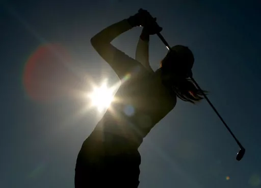 A golfer is silhouetted against the sun while teeing off on the third hole during the first round of the Women's British Open golf tournament at Royal Lytham and St Annes golf course in Lytham, north west England Thursday, Aug. 3, 2006. Kerry Bowie's daughters have dreams. Big ones. “There are some things people miss out on by not doing it,” Bowie says. “To be that young lady who plays golf, it changes things.” (AP Photo/Matt Dunham, File)