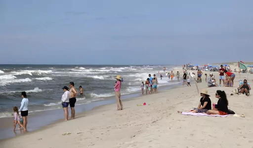 People are seen at Field 3 at Robert Moses State Park in West Islip, N.Y., Tuesday, July 4, 2023. Two swimmers were apparently attacked by sharks off the shores of Long Island on Tuesday, a day after two others reported being attacked while enjoying the water at popular New York beaches. (James Carbone/Newsday via AP)
