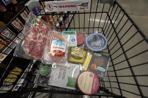 An assortment of vegan, organic, locally sourced, and wild caught food products all using plastic packaging, sit in a shopping cart at a grocery store in New Orleans, Wednesday, April 17, 2024. People are increasingly breathing, eating and drinking tiny particles of plastic, however, there are simple things people can do at the grocery store if they want to use less plastic. (AP Photo/Gerald Herbert)