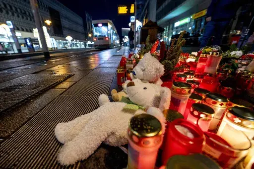 Teddy bears were laid together with candles near the Christmas market, where a car drove into a crowd on Friday evening, in Magdeburg, Germany, Sunday, Dec. 22, 2024. (AP Photo/Michael Probst)