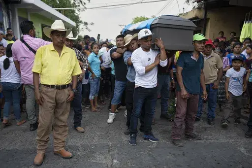 The casket of Miguel Rojche is carried from his home to the cemetery after his wake in Chicacao, Guatemala, Wednesday, April 12, 2023. Rojche and his nephew Francisco died in a fire while held at a Mexican immigration detention center in Ciudad Juarez. (AP Photo/Moises Castillo)