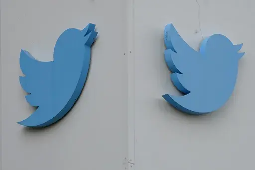 Twitter logos hang outside the company's offices in San Francisco, Monday, Dec. 19, 2022. Ella Irwin, a top Twitter executive responsible for safety and content moderation, has left the company. Her departure came after owner Elon Musk publicly complained about the platform’s handling of posts about transgender topics. (AP Photo/Jeff Chiu, File)