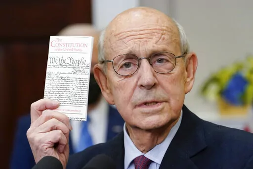 Supreme Court Associate Justice Stephen Breyer holds up a copy of the United States Constitution as he announces his retirement in the Roosevelt Room of the White House in Washington, Thursday, Jan. 27, 2022. Democratic Rep. Jim Clyburn and Republican Sen. Lindsey Graham say it would be good if the person named to replace retiring Breyer doesn’t have an Ivy League degree. (AP Photo/Andrew Harnik, File)