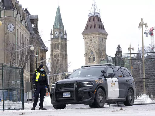 A police officer mans a checkpoint near Parliament Hill, Wednesday, Feb. 23, 2022 in Ottawa. Ottawa protesters who vowed never to give up are largely gone, chased away by police in riot gear in what was the biggest police operation in the nation’s history.  (Adrian Wyld /The Canadian Press via AP)