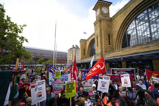 People holds banners and placards as they attend a RMT (The National Union of Rail, Maritime and Transport Workers) union train strike rally outside King's Cross railway station, in London, June 25, 2022. Across Europe, soaring inflation is behind a wave of protests and strikes that underscores growing discontent with spiralling living costs and threatens to unleash political turmoil. (AP Photo/Matt Dunham, file)