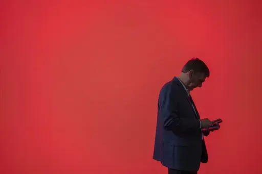 A visitor looks at his phone at the Mobile World Congress 2024 in Barcelona, Spain, Feb. 27, 2024. According to some un-scientific studies, the average person has hundreds of passwords to their name. (AP Photo/Pau Venteo, File)