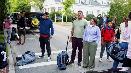 Migrants, who arrived on a flight sent by Florida Gov. Ron DeSantis, gather with their belongings outside St. Andrews Episcopal Church, Wednesday Sept. 14, 2022, in Edgartown, Mass., on Martha's Vineyard. A Texas sheriff on Monday, Sept. 19 opened an investigation into two flights of migrants sent to Martha's Vineyard by DeSantis, but did not say what laws may have been broken in putting 48 Venezuelans on private planes last week from San Antonio. (Ray Ewing/Vineyard Gazette via AP, File)