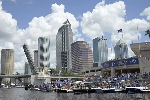Tampa Bay Lightning fans watch from boats with the downtown skyline in the background during the NHL hockey Stanley Cup champions' boat parade, July 12, 2021, in Tampa, Fla. On Thursday, Dec. 21, 2023, the city of Tampa reached an agreement with the federal government to resolve a discrimination lawsuit alleging that male workers didn't receive the same parental leave as female workers. (AP Photo/Phelan M. Ebenhack, File)