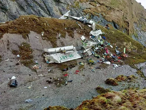 This handout photograph released by Fishtail Air, shows the wreckage of a plane in a gorge in Sanosware in Mustang district close to the mountain town of Jomsom, west of Kathmandu, Nepal, Monday, May 30, 2022. The wreckage of a plane carrying 22 people that disappeared in Nepal's mountains was found Monday scattered on a mountainside, the army said. There was no word on survivors. (Fishtail Air via AP)