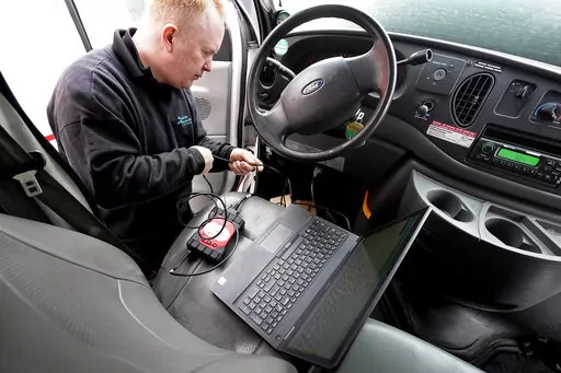 Brian Hohmann, mechanic and owner of Accurate Automotive, in Burlington, Mass., attaches a diagnostics scan tool, center left, to a vehicle and a laptop computer, below, Tuesday, Feb. 1, 2022, in Burlington. The diagnostics scan tool sends information from the vehicle's computer to the laptop so a mechanic can view information about the vehicle's performance. Hohmann said most independent shops are perfectly capable of competing with dealerships on both repair skills and price as long as they ha